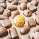 Gold-wrapped chocolate truffle surrounded by unwrapped chocolate
